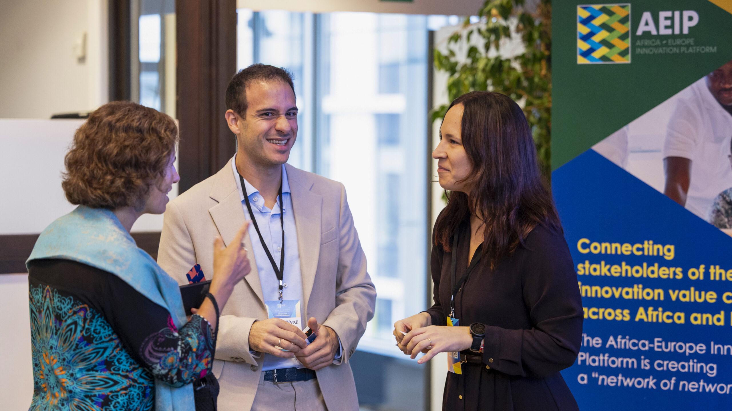 Silvia Diazzi and Konstantinos Maragkos from Youthmakers Hub discussing with a person at the Africa-Europe Innovation Dialogues 2025